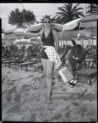 Grace Kelly standing on the beach in sunglasses photo print