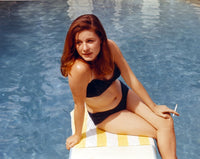 Patty Duke seated on a diving board in blue two-piece swimsuit photo print.