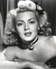 Close-up portrait of Lana Turner with ribbon and amulet necklace, vintage photo print.