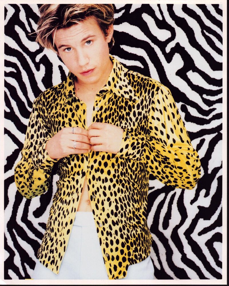 Jonathan Taylor Thomas photo print in cheetah shirt against zebra wall.
