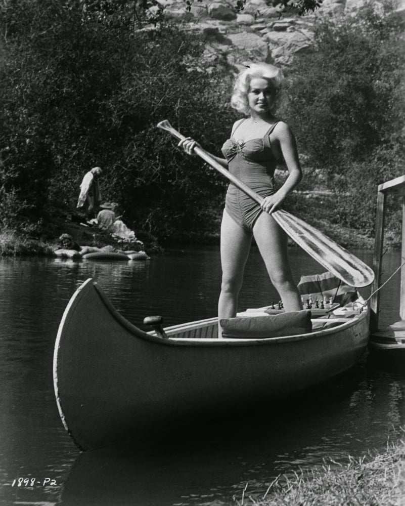 Mamie Van Doren standing in canoe photo print, available in various sizes.