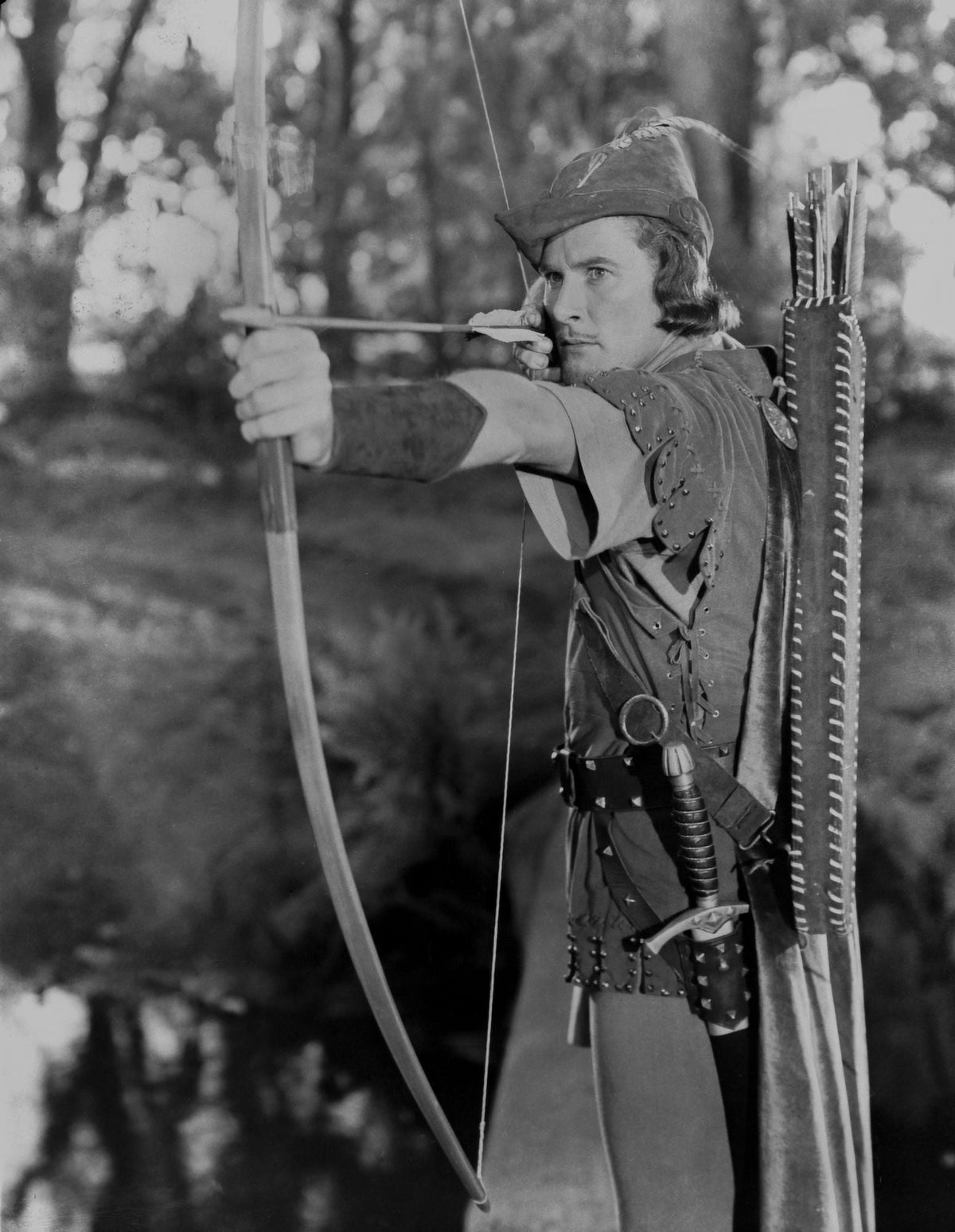 Errol Flynn as Robin Hood photo print capturing the actor in action with a bow and arrow.
