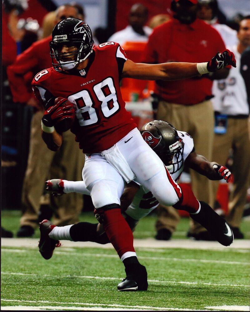 Tony Gonzalez running with football photo print, showcasing athletic prowess.