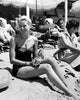 Grace Kelly sitting on beach in black bathing suit photo print