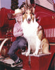 Lassie portrait with a boy posed on a red car photo print.