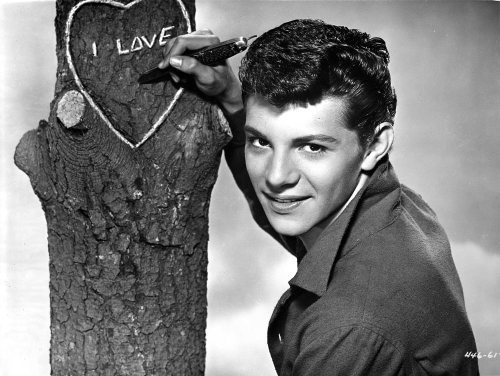 Frankie Avalon carving a love heart in a tree photo print