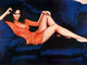 Lynda Carter photo print in orange dress on blue couch, 10x8