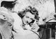 Bette Davis lying on bed talking on phone in white silk shirt photo print