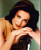 Kim Delaney photo print seated in a gold top, elegant decor piece.