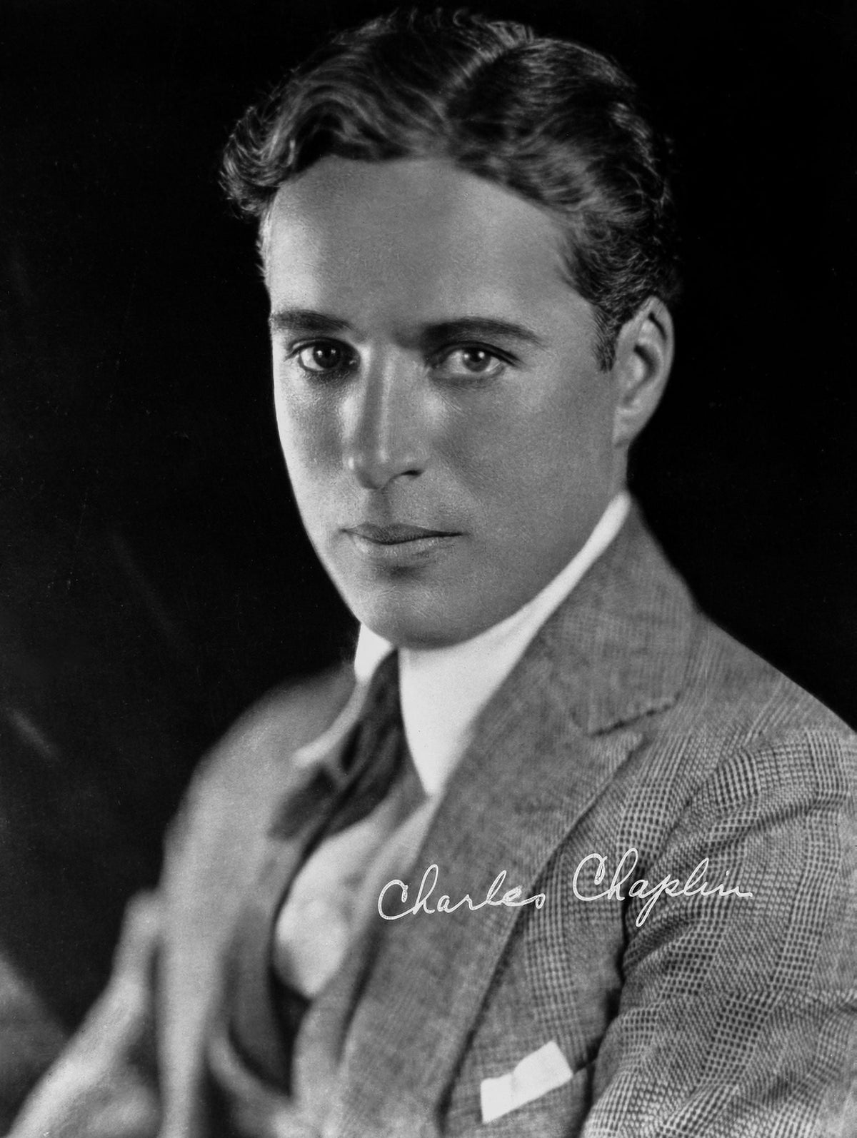 Charlie Chaplin photo print in gray suit and tie.