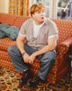 Candid photo print of Chris Farley sitting on a couch.