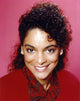 Jasmine Guy smiling in a red coat photo print