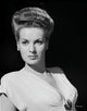 Maureen O'Hara wearing a white V-neck dress on a black background photo print.