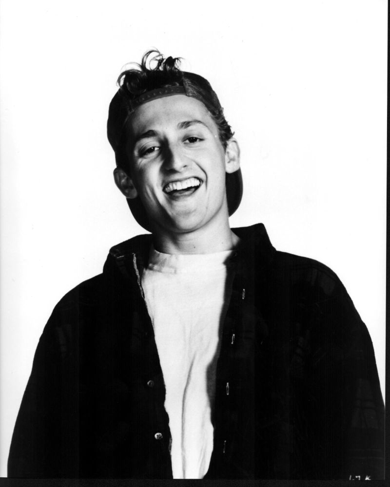 Black and white photo print of Alex Winter wearing a backwards hat and jacket