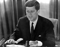 John F. Kennedy sitting at a desk photo print.