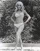 Black and white photo print of Stella Stevens in bikini posing with hands on hips.