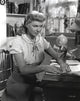 Doris Day seated in a classic candid photo with a doll, available as a print.