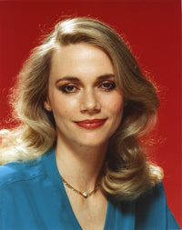 Peggy Lipton smiling portrait in blue dress with red background photo print