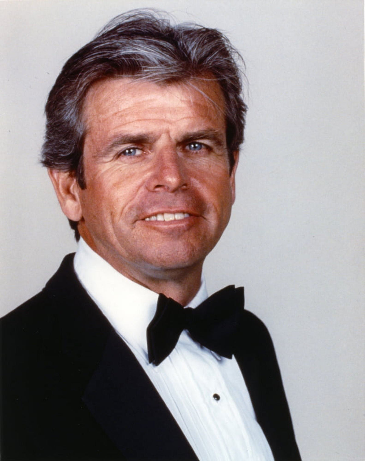 William Devane posed in classic black suit with bow tie photo print