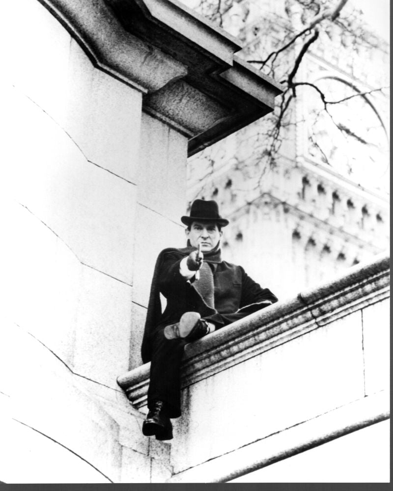 Black and white photo print of Jeremy Brett sitting on a wall, capturing a classic moment.