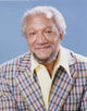 Redd Foxx portrait photo print in checkered coat with sky blue background.