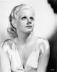 Jean Harlow portrait photo print in deep V-neck silk dress, looking up with hands on lap.