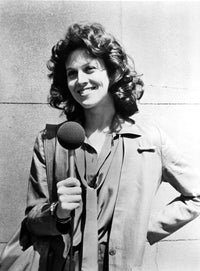 Sigourney Weaver holding a microphone in a classic photo print.