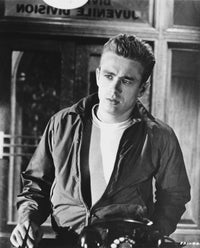 James Dean iconic photo print in black silk jacket and white t-shirt, left hand on waist, looking to the right.