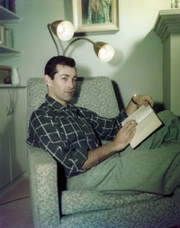 Rick Jason photo print of him relaxing on the couch reading a book.