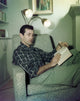 Rick Jason photo print of him relaxing on the couch reading a book.