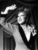 Bette Midler waving portrait in grey linen dress photo print