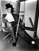 Fred Astaire seated on a chair in a classic black and white portrait photo print.