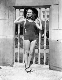 Vintage photo print of Betty Grable in swimsuit and black hat.