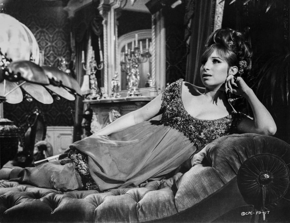 Barbra Streisand leaning on a couch in a black dress photo print.