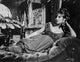 Barbra Streisand leaning on a couch in a black dress photo print.