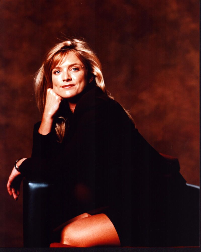 Courtney Thorne-Smith leaning on a chair in a black suit photo print