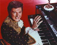 Liberace performing with pianist photo print in red background.