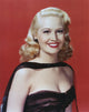 Marilyn Maxwell smiling in black dress photo print with red background.