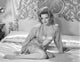 Black and white photo print of Angie Dickinson sitting in bed, capturing classic Hollywood elegance.