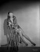 Black and white portrait photo print of Barbara Stanwyck sitting on a chair.