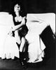 Laura San Giacomo black and white photo print sitting on bed in boots.