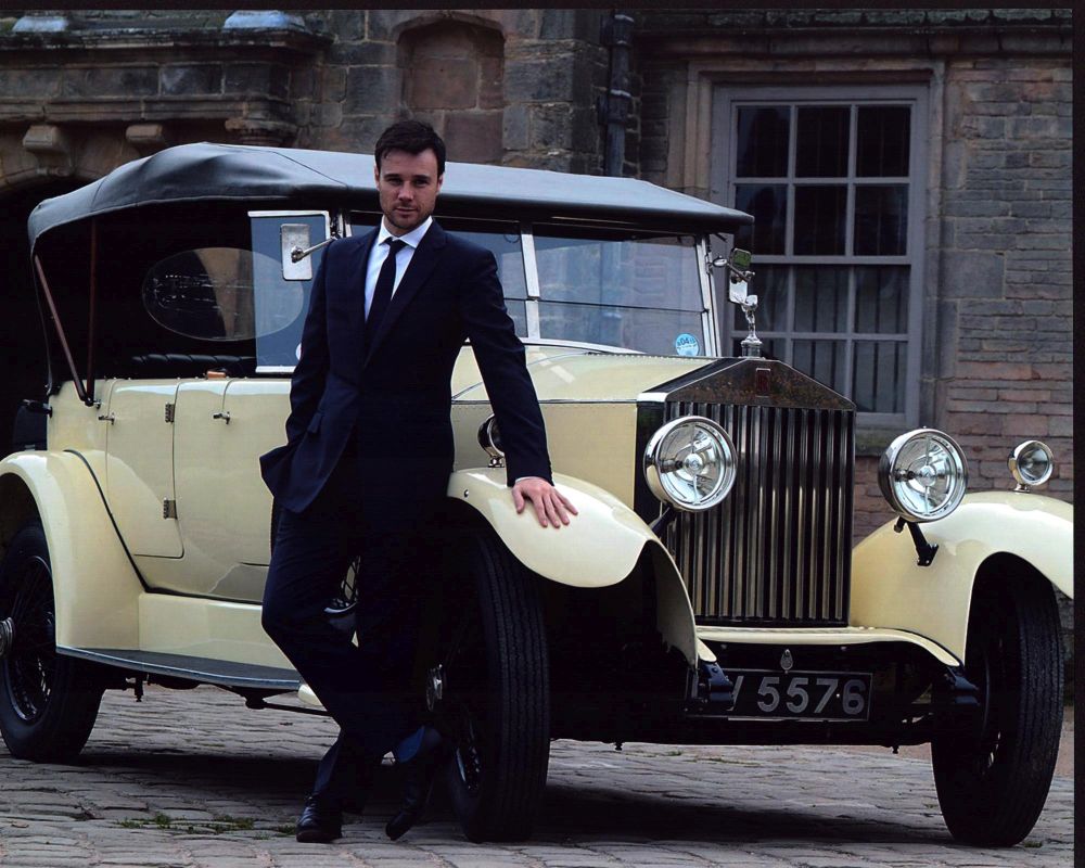 Rupert Evans in front of a yellow Rolls-Royce photo print