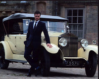 Rupert Evans in front of a yellow Rolls-Royce photo print