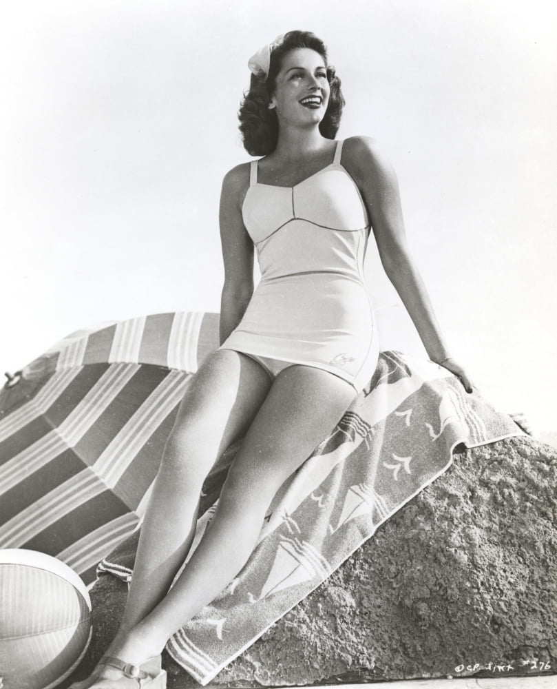 Jinx Falkenburg photo print sitting on a big rock in a one piece.