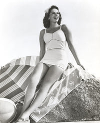 Jinx Falkenburg photo print sitting on a big rock in a one piece.