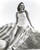 Jinx Falkenburg photo print sitting on a big rock in a one piece.