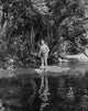 Johnny Weissmuller standing on a rock in a classic movie scene photo print