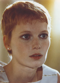 Close-up portrait of Mia Farrow wearing a white printed tank top.