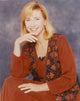 Photo print of Kathy Baker smiling in a red dress.