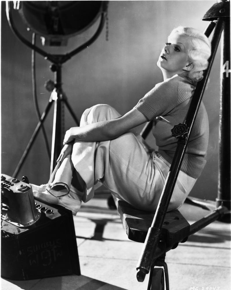 Jean Harlow seated with knees bent in a black shirt and white skirt photo print.